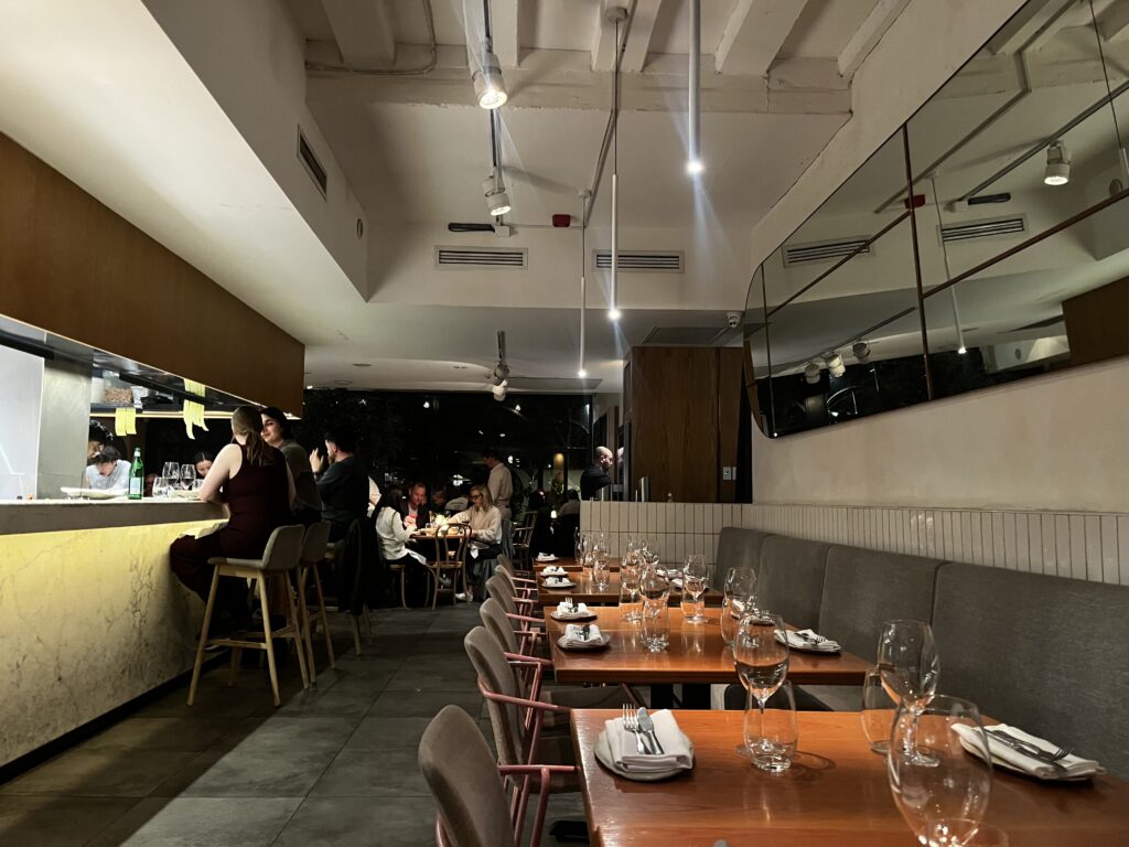nour interior with warm tables, seating and clean white walls and ceilings