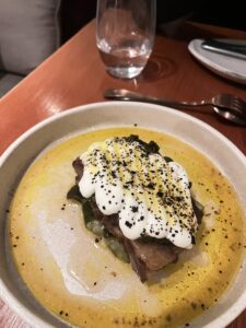 lamb neck served on a bed of soft zucchini and topped with yoghurt sauce