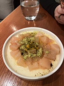 milk pudding topped with pink poached pear and crushed green pistachios
