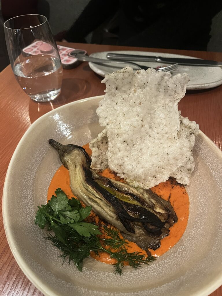 woodfired eggplant served with fresh green herbs, a light and tangy orange sauce and a crispy cracker