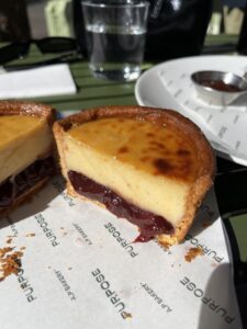 vanilla cinnamon blood plum flan cross section with golden flan, browned pastry, and deep velvet red plum filling at the bottom